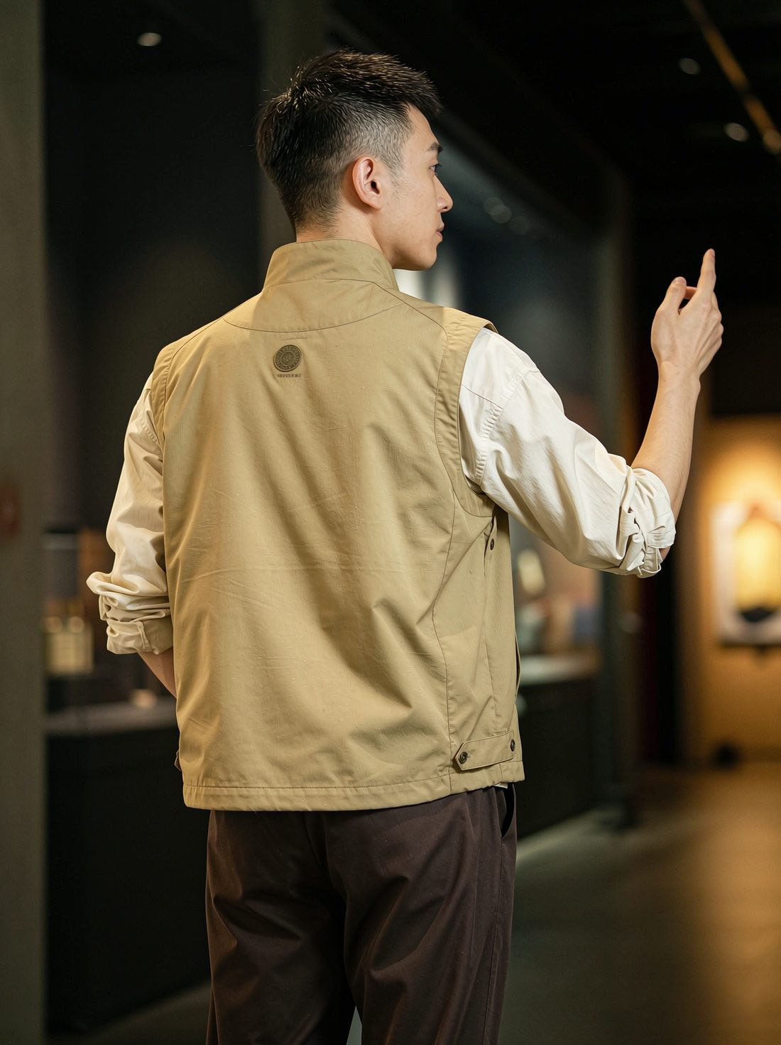 身穿卡其马甲的守信人在展厅内为游客指路